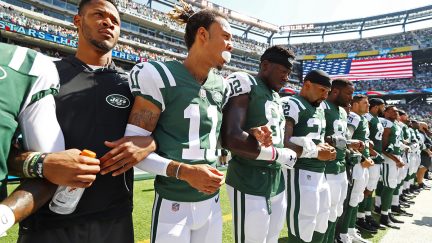 New York Jets stand in unison during National Anthem prior to an NFL game against the Miami Dolphins at MetLife Stadium on September 24, 2017