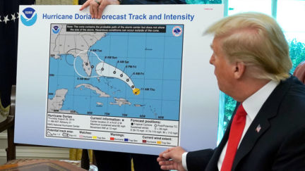 Donald Trump in Oval Office with altered Hurricane Dorian projection map