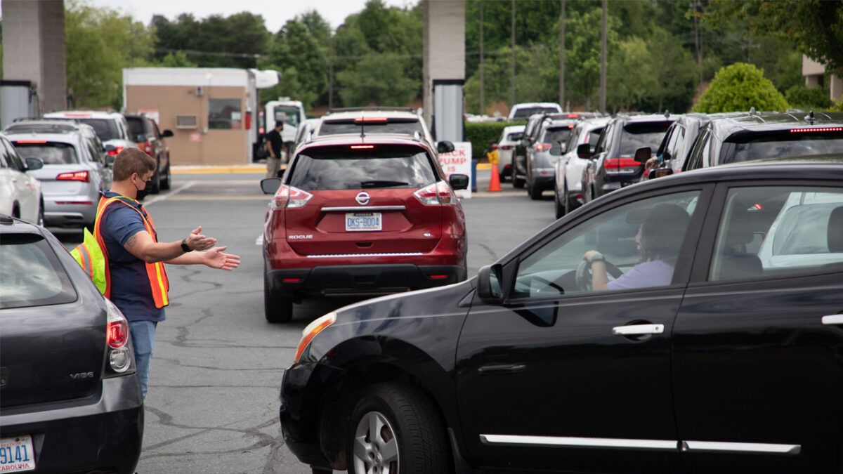 Attendants direct cars as they line up to fill their gas tanks at in Charlotte, North Carolina on May 11, 2021