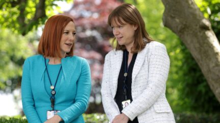 WASHINGTON, DC - MAY 13: White House Press Secretary Jen Psaki (L) and White House Communications Director Kate Bedingfield (R) wait for President Joe Biden to deliver remarks on the COVID-19 response and vaccination program in the Rose Garden of the White House on May 13, 2021 in Washington, DC. The Centers for Disease Control and Prevention (CDC) announced today that fully vaccinated people will no longer need to wear masks or socially distance for indoor and outdoor activities in most settings. (Photo by Alex Wong/Getty Images)
