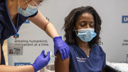 UCLA ER doctor Medell Briggs-Malonson closes her eyes as she gets prepped for inoculation of the Covid-19 vaccine from nurse Eunice Lee at Ronald Reagan UCLA Medical Center in Westwood, California on December 16, 2020