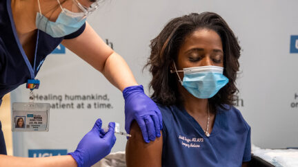 UCLA ER doctor Medell Briggs-Malonson closes her eyes as she gets prepped for inoculation of the Covid-19 vaccine from nurse Eunice Lee at Ronald Reagan UCLA Medical Center in Westwood, California on December 16, 2020