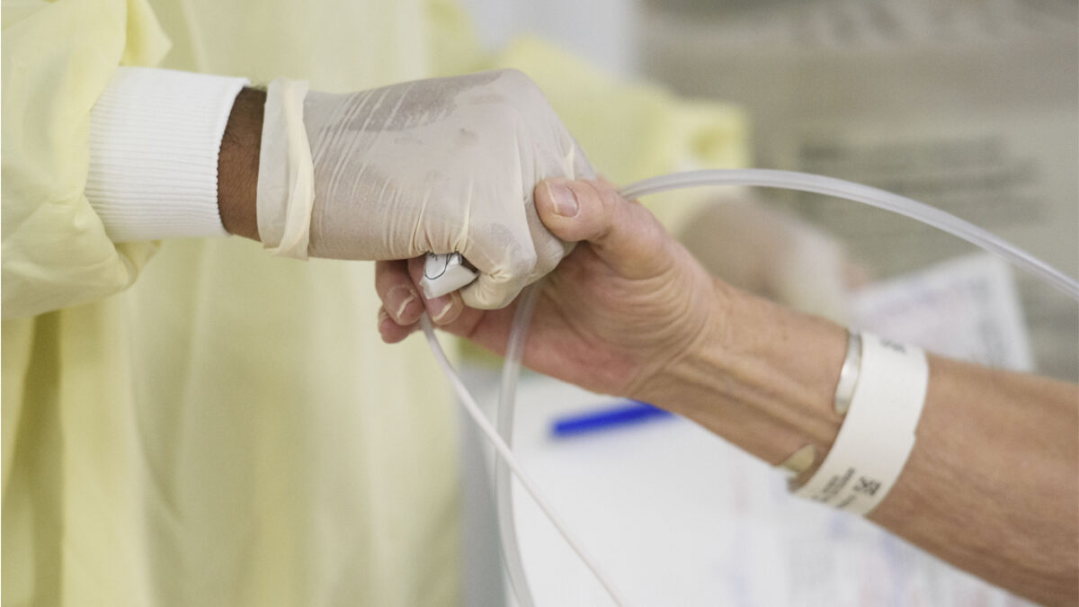Doctor holds patient hand at Covid alternative care site in Nevada