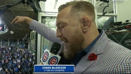 Conor McGregor sings during the seventh-inning stretch at Wrigley Field