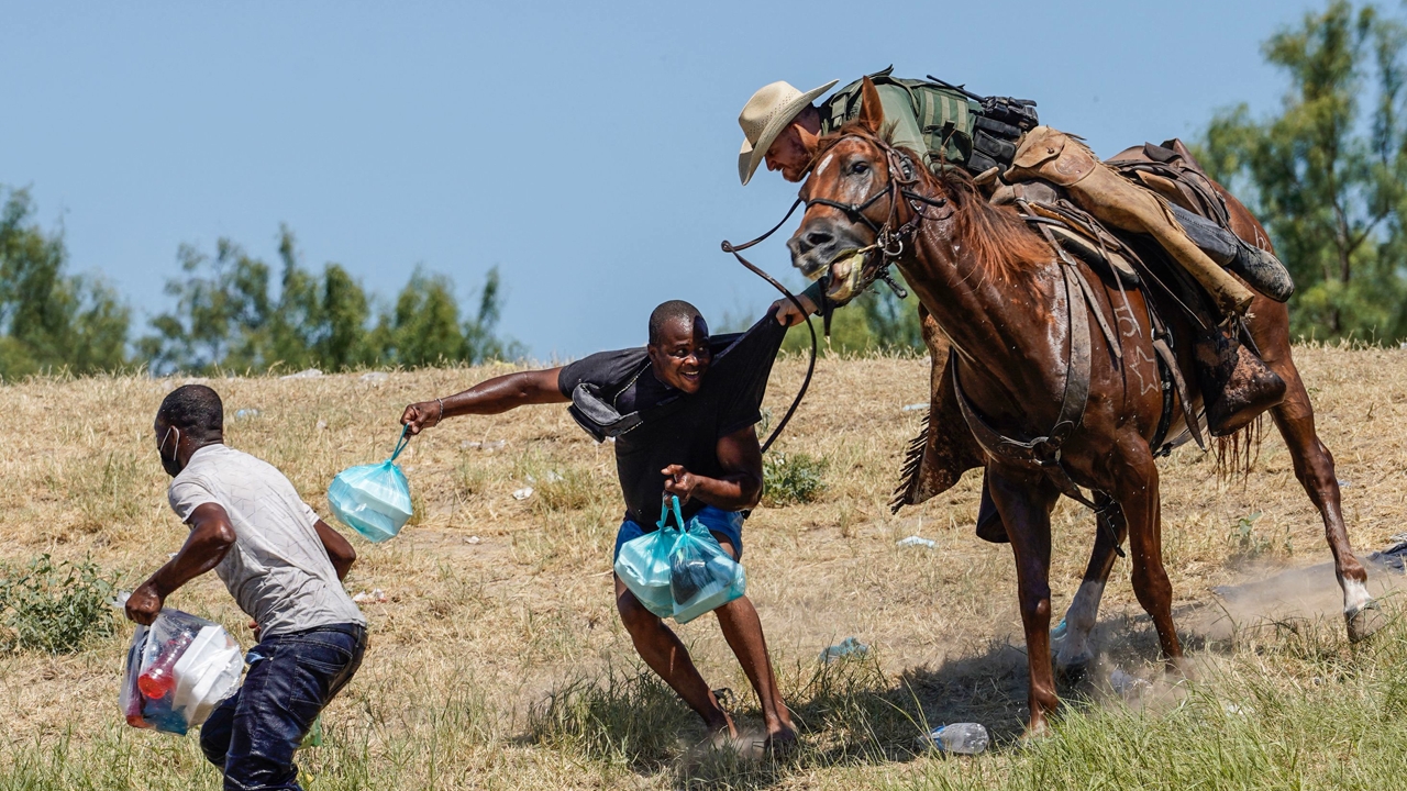 TOPSHOT - A United States Border Patrol officer on horseback attempts to prevent a Haitian migrant from entering an encampment on the banks of the Rio Grande near the Acuna Del Rio International Bridge in Del Rio, Texas, September 19, 2021 - The United States said on Saturday it would increase deportation flights for thousands of migrants who have flocked to the Texas border town of Del Rio as authorities scramble to alleviate an emerging crisis for the administration by President Joe Biden.