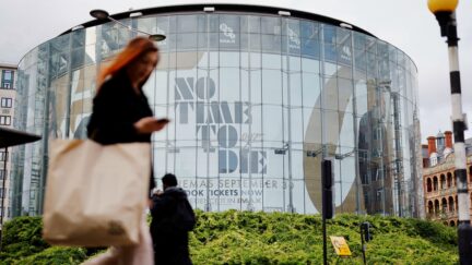 A pedestrian walks past a billboard of the latest James Bond film 