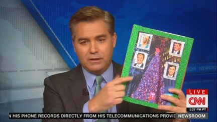 Jim Acosta holding pic of Fox News Christmas tree and hosts