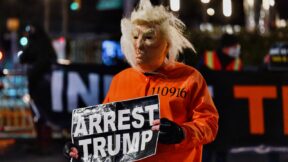 A man dressed as Trump in a prison jump suit protests in front of Trump International Hotel & Tower on January 06, 2021 in New York City. - Donald Trump's supporters stormed a session of Congress held today, January 6, to certify Joe Biden's election win, triggering unprecedented chaos and violence at the heart of American democracy and accusations the president was attempting a coup. (Photo by Angela Weiss / AFP) (Photo by ANGELA WEISS/AFP via Getty Images)