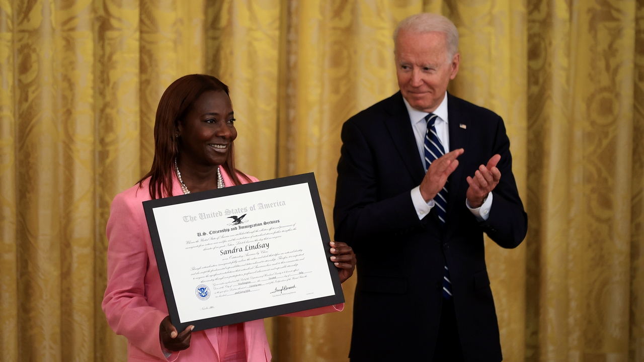 WASHINGTON, DC - JULY 02: Jamaican immigrant Sandra Lindsay is presented with the U.S. Citizenship and Immigration Services' Outstanding Citizen By Choice award by U.S. President Joe Biden during a naturalization ceremony in the East Room of the White House on July 02, 2021 in Washington, DC. Lindsay, a nurse from Long Island, New York, was the first person in the United States to be fully vaccinated agains the coronavirus. (Photo by Chip Somodevilla/Getty Images)
