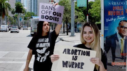MIAMI, FLORIDA - MAY 03: Amanda Guerra (R) holds a sign reading, 'Abortion is Murder' as she counter protests during a rally supporting the right for abortions to be protected by the federal government on May 03, 2022 in Miami, Florida. In a leaked initial draft majority opinion obtained by Politico and authenticated by Chief Justice John Roberts, Supreme Court Justice Samuel Alito wrote that the cases Roe v. Wade and Planned Parenthood of Southeastern Pennsylvania v. Casey should be overturned, which would end federal protection of abortion rights across the country. (Photo by Joe Raedle/Getty Images)