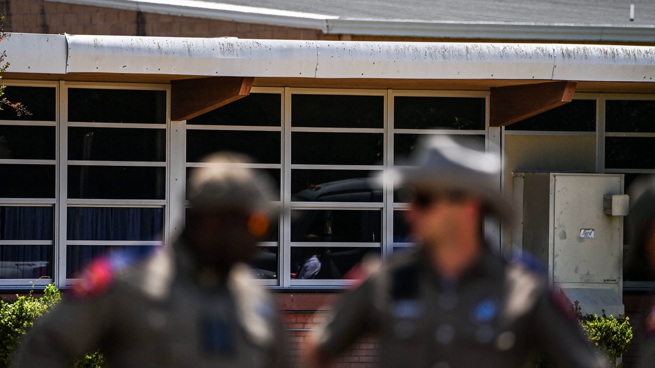 Police officers stand outside the Robb Elementary School in Uvalde, Texas, on May 25, 2022. - The tight-knit Latino community of Uvalde was wracked with grief Wednesday after a teen in body armor marched into the school and killed 19 children and two teachers, in the latest spasm of deadly gun violence in the US. (Photo by CHANDAN KHANNA / AFP) (Photo by CHANDAN KHANNA/AFP via Getty Images)