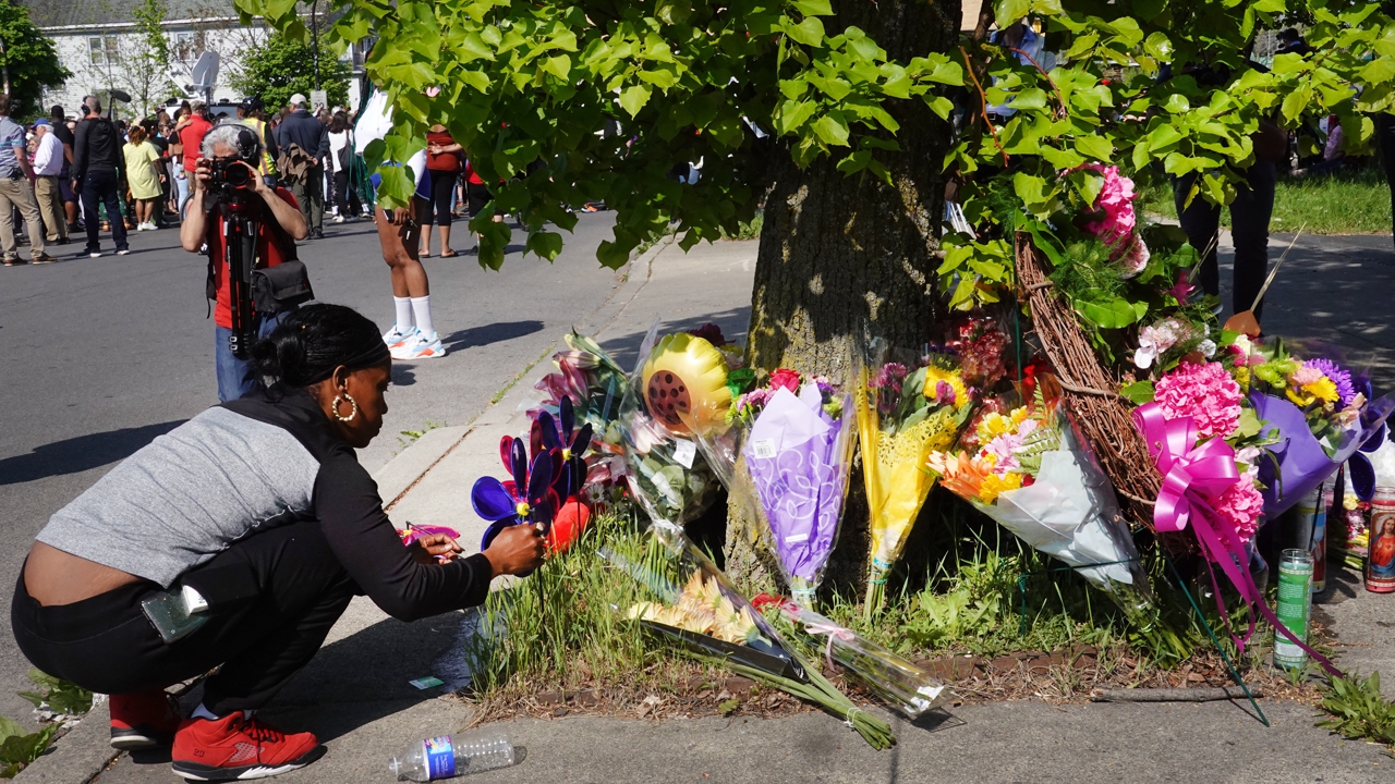 BUFFALO, NEW YORK - MAY 15:  Flowers are left at a makeshift memorial outside of Tops market on May 15, 2022 in Buffalo, New York. Yesterday a gunman opened fire at the store, killing ten people and wounding another three. Suspect Payton Gendron was taken into custody and charged with first degree murder. U.S. Attorney Merrick Garland released a statement, saying the US Department of Justice is investigating the shooting "as a hate crime and an act of racially-motivated violent extremism".  (Photo by Scott Olson/Getty Images)