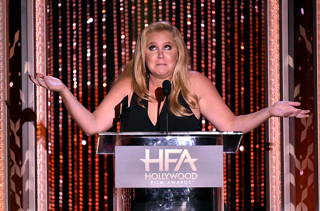 amy schumer with her arms raised looking puzzled