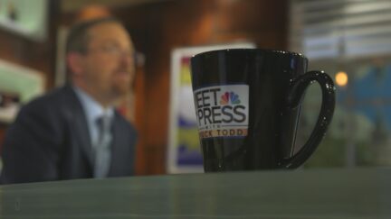 Meet the Press coffee cup on set with Chuck Todd in the background
