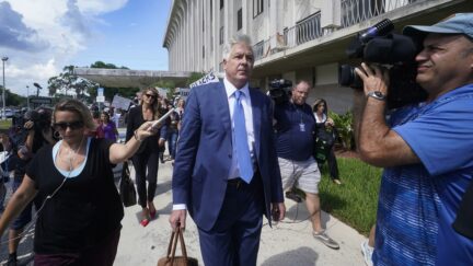 Attorney Evan Corcoran, center, leaves the Paul G. Rogers Federal Building and U.S. Courthouse in West Palm Beach, Fla., Thursday, Sept. 1, 2022. A federal judge has heard arguments on whether to appoint an outside legal expert to review government records seized by the FBI last month in a search of former President Donald Trump's Florida home. There was no immediate ruling after arguments Thursday.