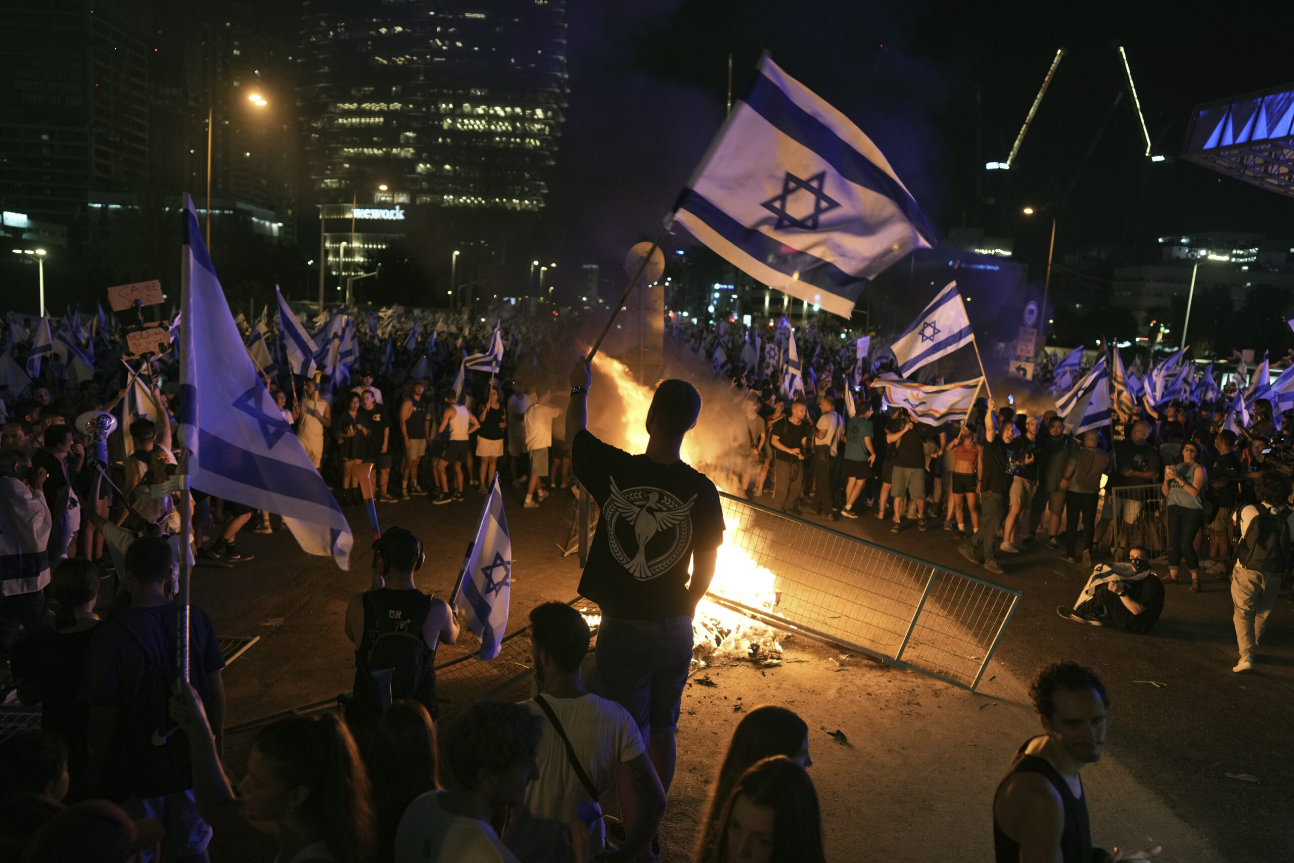 Demonstrators protest against plans by Prime Minister Benjamin Netanyahu's government to overhaul the judicial system, in Tel Aviv, Monday, July 24, 2023. Israeli lawmakers on Monday approved a key portion of Prime Minister Benjamin Netanyahu's divisive plan to reshape the country's justice system despite massive protests that have exposed unprecedented fissures in Israeli society. 