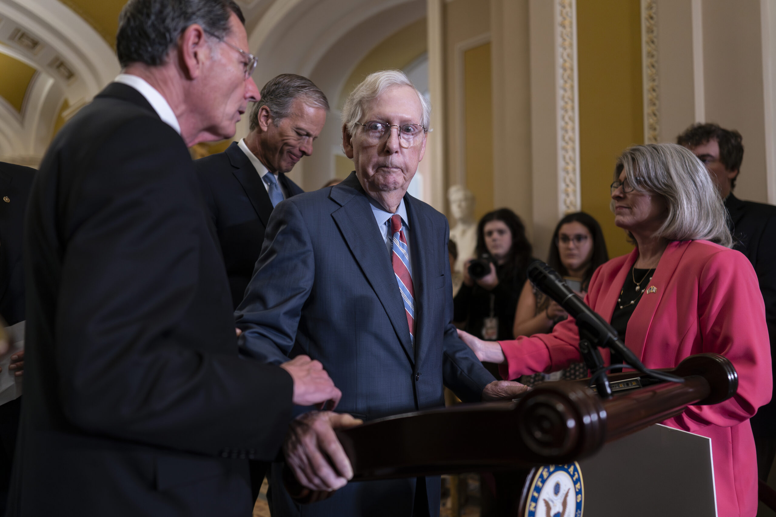 Senate Minority Leader Mitch McConnell, R-Ky., center, is helped by, from left, Sen. John Barrasso, R-Wyo., Sen. John Thune, R-S.D., and Sen. Joni Ernst, R-Iowa, after the 81-year-old GOP leader froze at the microphones as he arrived for a news conference, at the Capitol in Washington, Wednesday, July 26, 2023. McConnell went to his office for a few minutes and returned to speak with reporters.