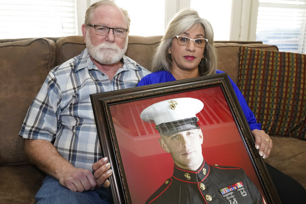 FILE - Joey and Paula Reed pose for a photo with a portrait of their son, Marine veteran and Russian prisoner Trevor Reed, at their home in Fort Worth, Texas, Feb. 15, 2022. Negotiations between the U.S. and Russia led to basketball star Brittney Griner's return to the U.S. on Friday, Dec. 9, 2022, in exchange for notorious arms dealer Viktor Bout. It is the latest in a series of high-profile prisoner swaps involving Americans detained abroad, one of whom was Reed, an American imprisoned in Russia for nearly three years. He was swapped for Konstantin Yaroshenko, a Russian pilot who had been serving a 20-year federal sentence for conspiring to smuggle cocaine into the U.S. 