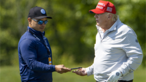 FILE - Walt Nauta, left, takes a phone from Former President Donald Trump during the LIV Golf Pro-Am at Trump National Golf Club, May 25, 2023, in Sterling, Va. Nauta is set to be arraigned on charges that he helped the former president hide classified documents that the Justice Department wanted back. Nauta was charged earlier this month alongside Trump in a 38-count indictment filed by Justice Department special counsel Jack Smith.