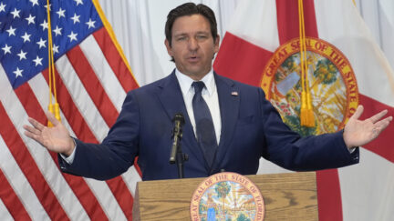 Ron DeSantis in front of U.S. and Florida flags