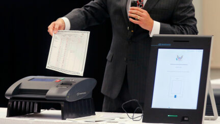 FILE - A Smartmatic representative demonstrates his company's system which has scanners and touch screens with printout options, at a meeting of the Secure, Accessible & Fair Elections Commission, Aug. 30, 2018, in Grovetown, Ga.