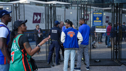 New York Knicks fans wait behind a security gate in front of Madison Square Garden ahead of Game 3 of the NBA Finals, Monday, June 8, 2026, in New York. (AP Photo/Ryan Murphy)