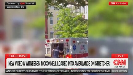 CNN image showing emergency personnel entering the back of an ambulance on a leafy street