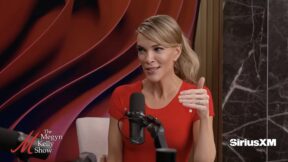 megyn kelly in red top with her hair pulled back sitting at a microphone