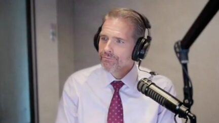 Scott Jennings on his radio show with a mic in front of him and headphones