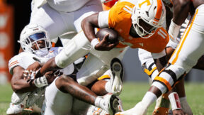 Texas defensive end Colin Simmons (1) brings down Tennessee quarterback Faizon Brandon (11) during the second half of an NCAA college football game in Knoxville, Tenn., Saturday, Sept. 26, 2026. (Sara Diggins/The San Antonio Express-News via AP)