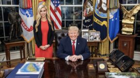 Zacharia in a red dress standing behind trump in oval office